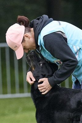 Une conductrice partage un moment de complicité avec son chien noir après un concours